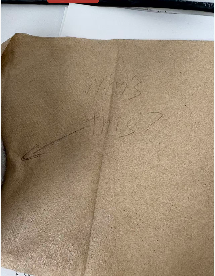 Note reading 'Who's this?' concealed beneath the tissues