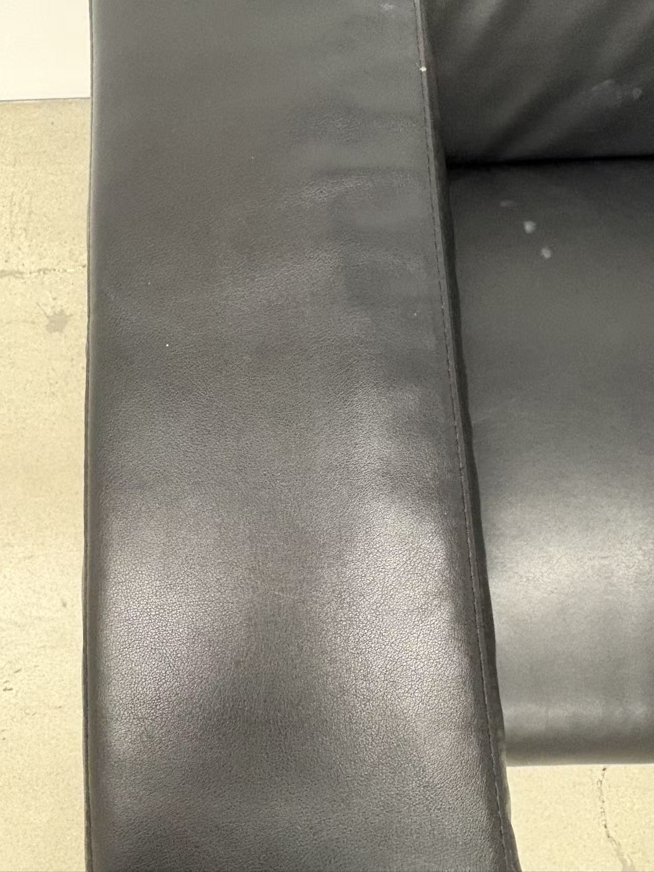 Leather sofa armrest where the electronic cigarette had rested, now empty